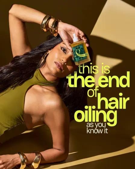 Model holding hair oil with bold typographic claim